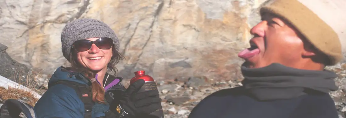 A guide and a trekker laughing together on the trail